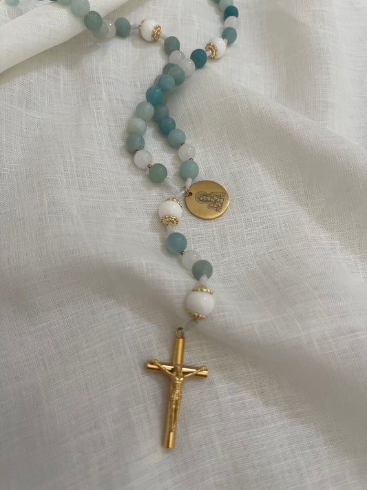 Handmade Catholic rosary featuring semi-precious amazonite stones, a gold Miraculous medal, and a gold crucifix on a minimal linen background.