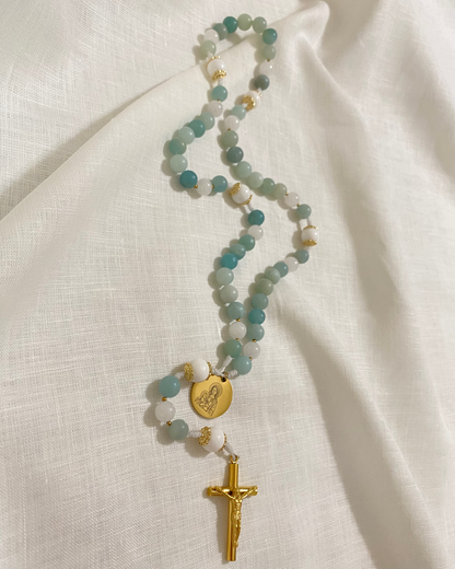 Handmade Catholic rosary featuring semi-precious amazonite stones, a gold Miraculous medal, and a gold crucifix on a minimal linen background.